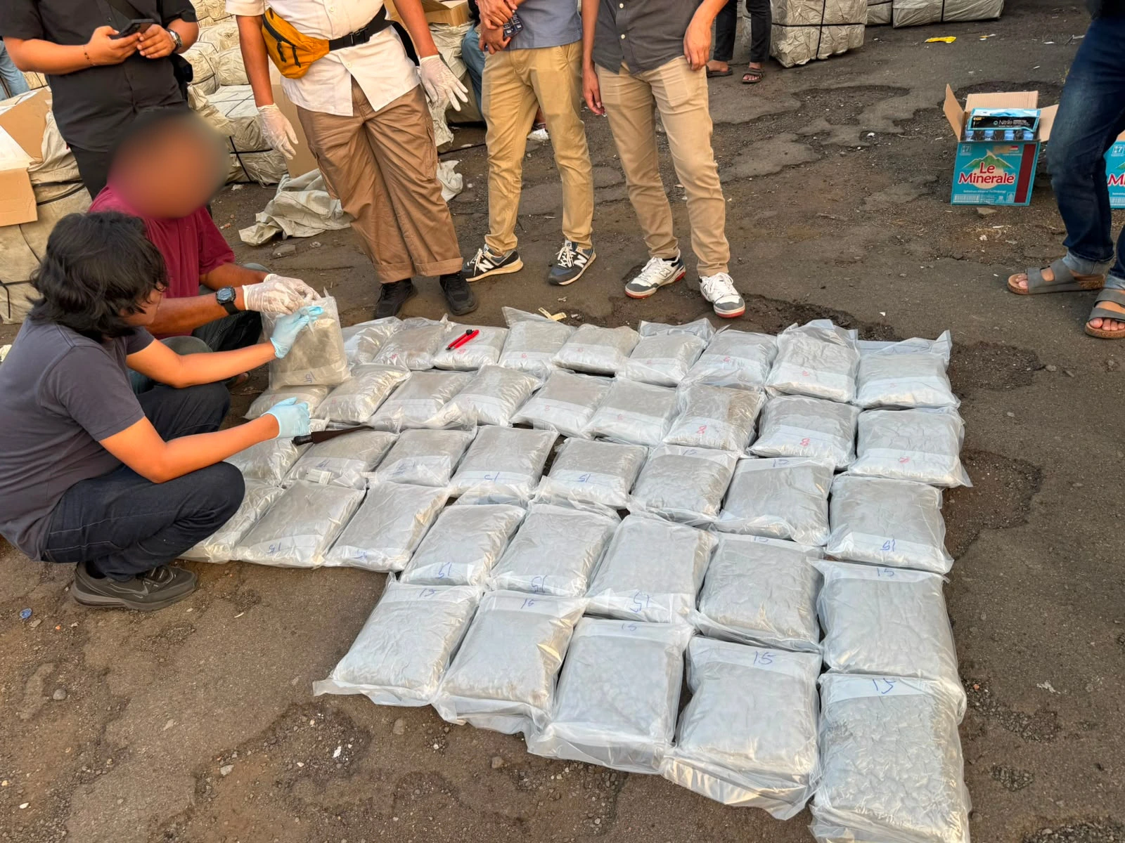 Barang bukti ganja yang disembunyikan di dalam gulungan matras lateks sedang diperiksa oleh petugas.